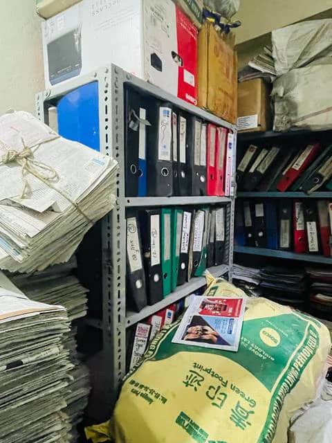 Binders and sacks stored together on open shelving