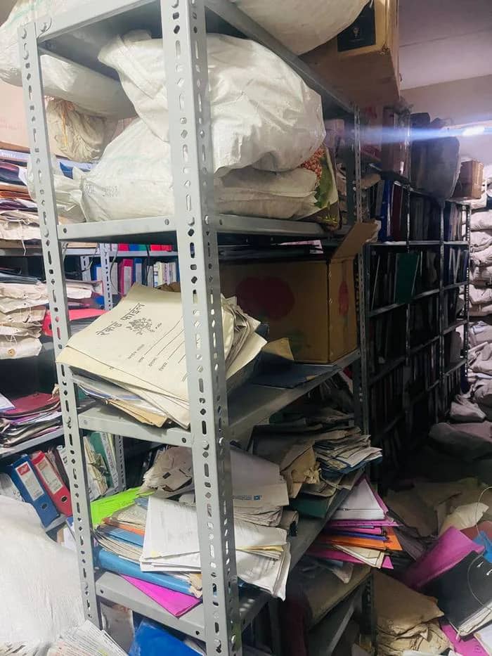 Overloaded storeroom shelving with loose files
