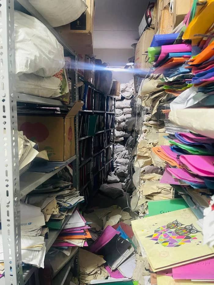 Storeroom with overloaded shelving and files in sacks